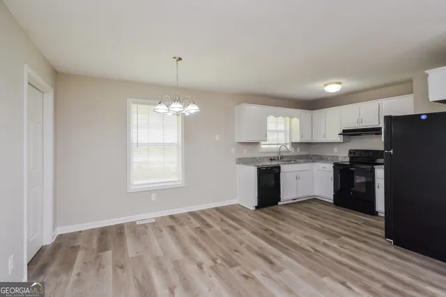 a kitchen with a refrigerator sink and cabinets