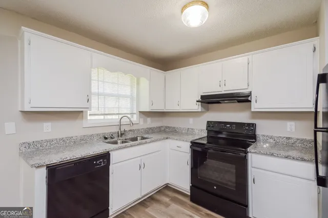 a kitchen with cabinets appliances a sink and a window