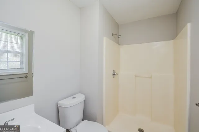 a white toilet sitting next to a bathroom sink