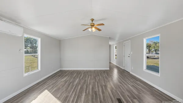 a view of a living room and a kitchen with wooden floor