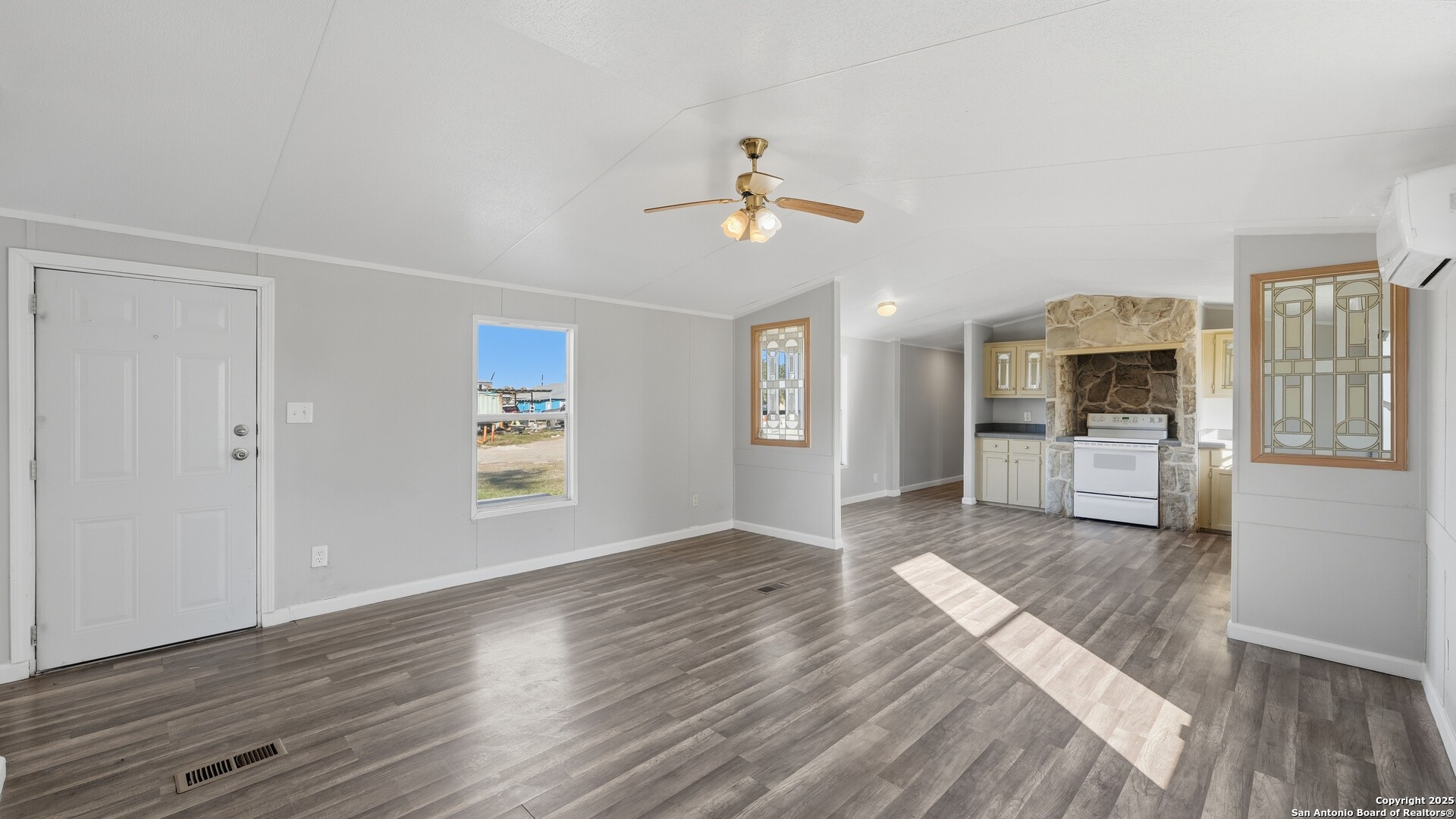 13895 Wisdom Road Atascosa, TX 78002 - Photo 19 of 48 a view of a living room and a kitchen with wooden floor