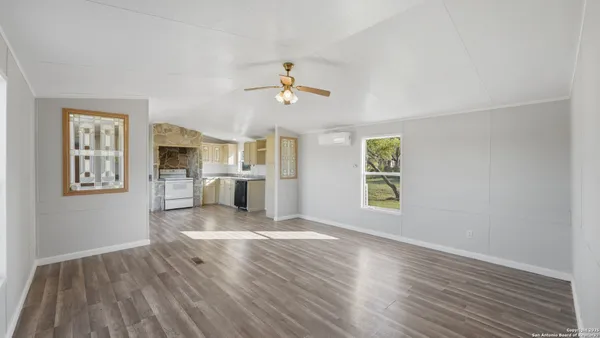 a kitchen with wooden floors and white cabinets