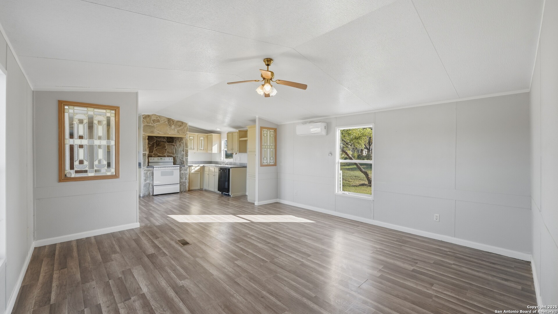 13895 Wisdom Road Atascosa, TX 78002 - Photo 20 of 48 a view of a kitchen with wooden floor and a ceiling fan