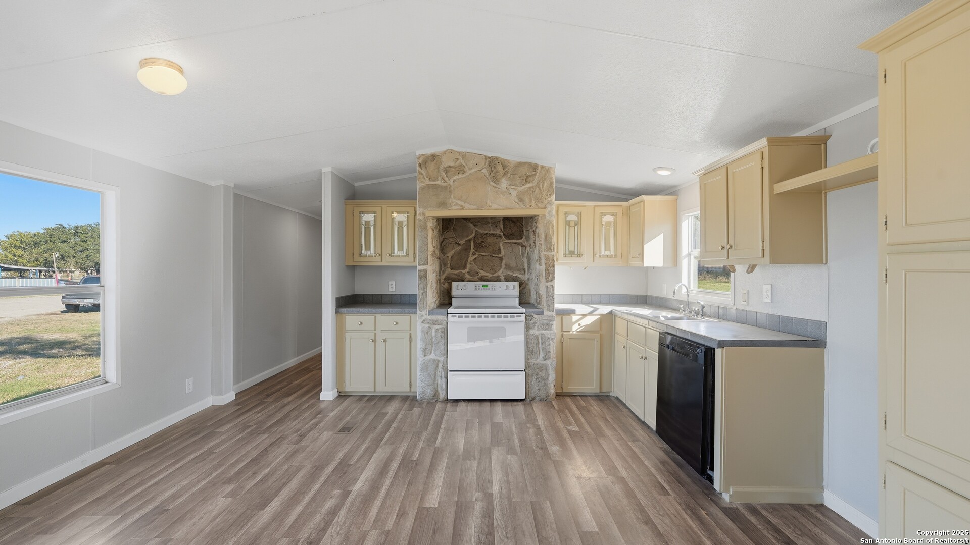 13895 Wisdom Road Atascosa, TX 78002 - Photo 21 of 48 a kitchen with wooden floors and white cabinets