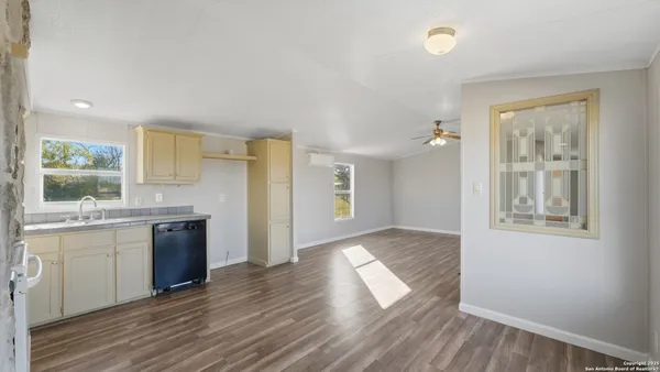 a kitchen with a sink cabinets stainless steel appliances and a window