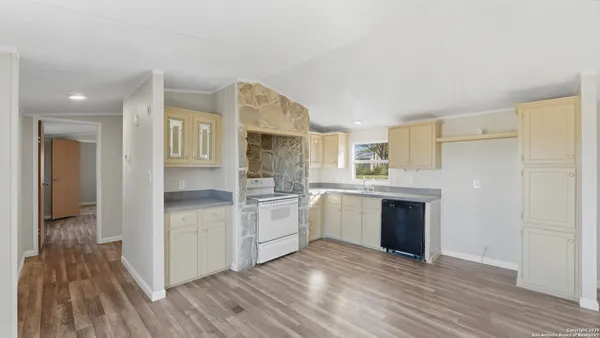 an empty room with wooden floor and window