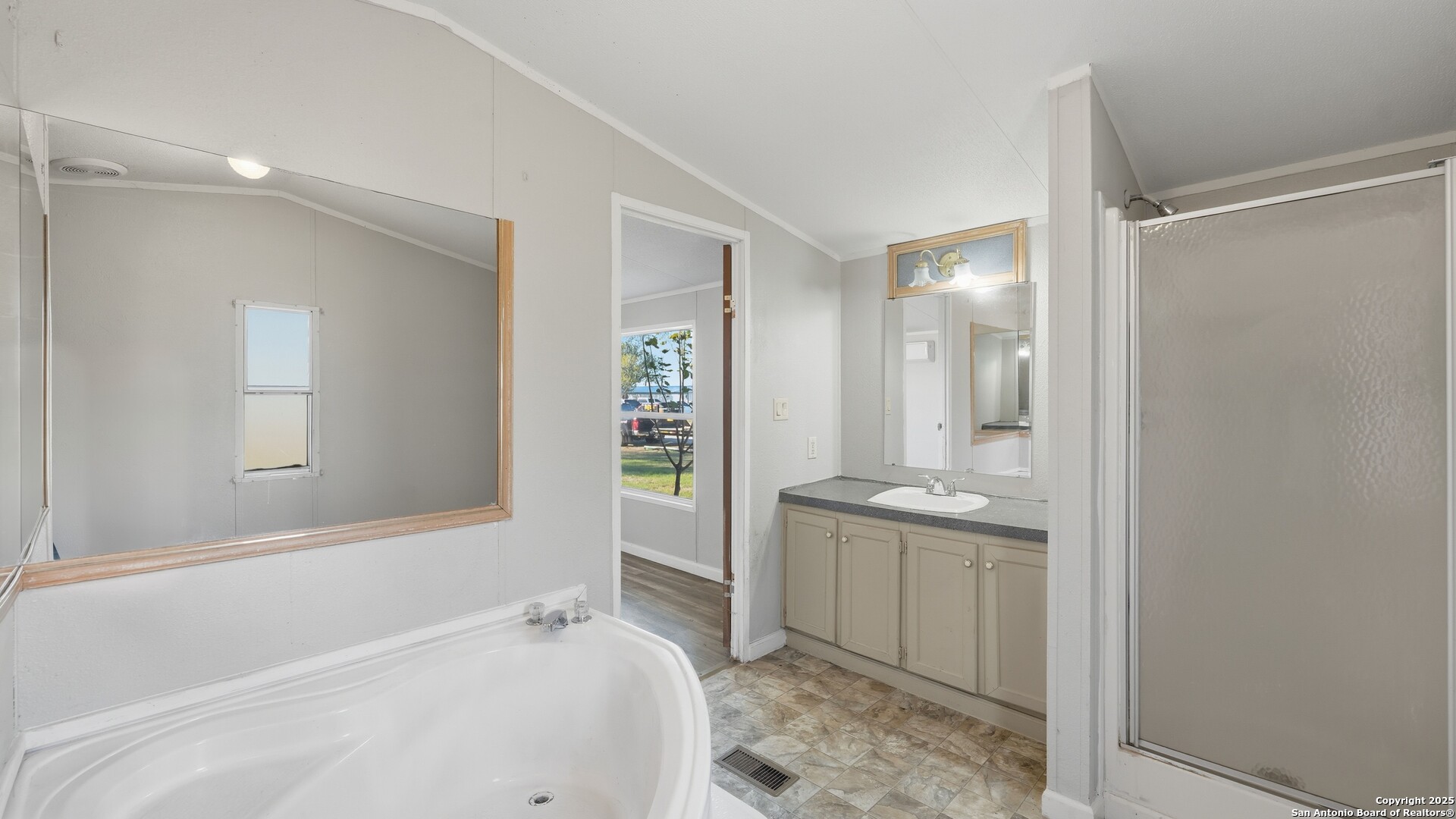 13895 Wisdom Road Atascosa, TX 78002 - Photo 26 of 48 a bathroom with a tub sink and mirror