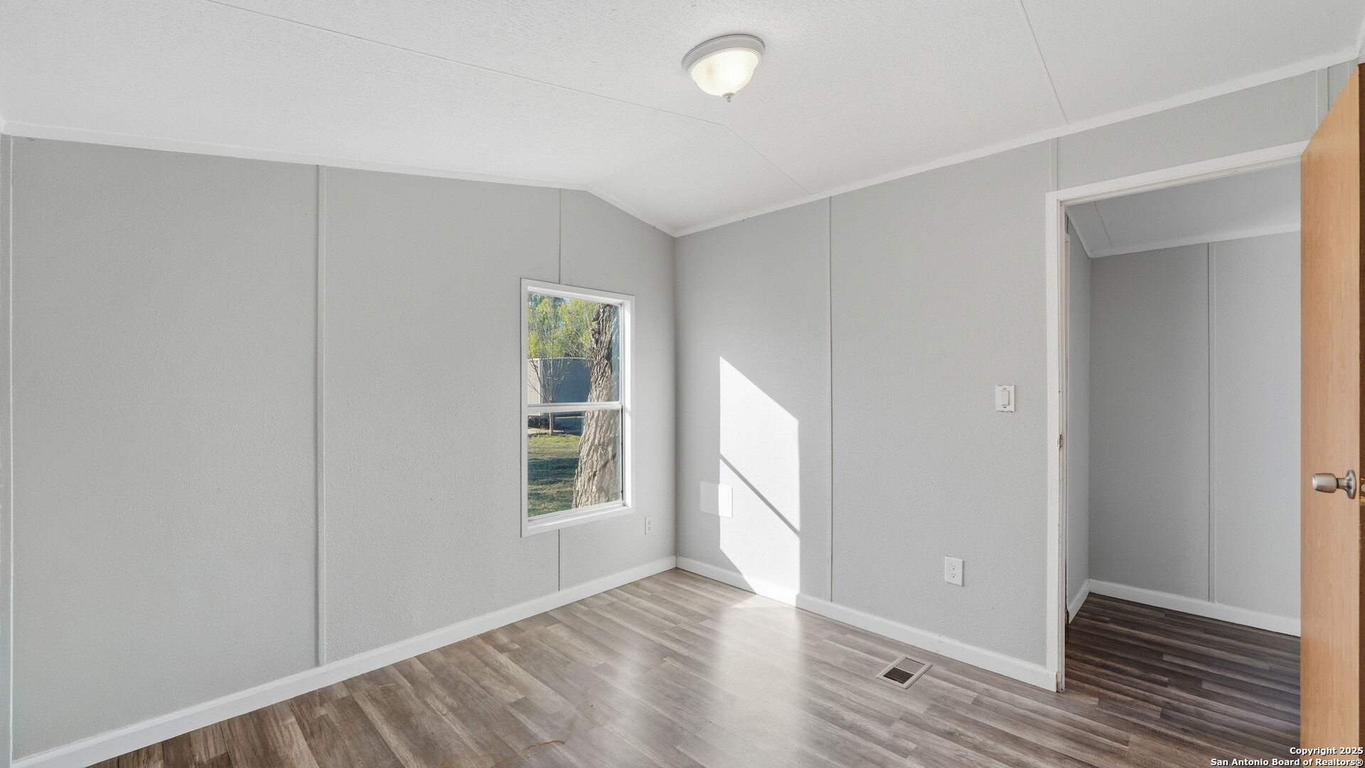 13895 Wisdom Road Atascosa, TX 78002 - Photo 29 of 48 an empty room with wooden floor and windows