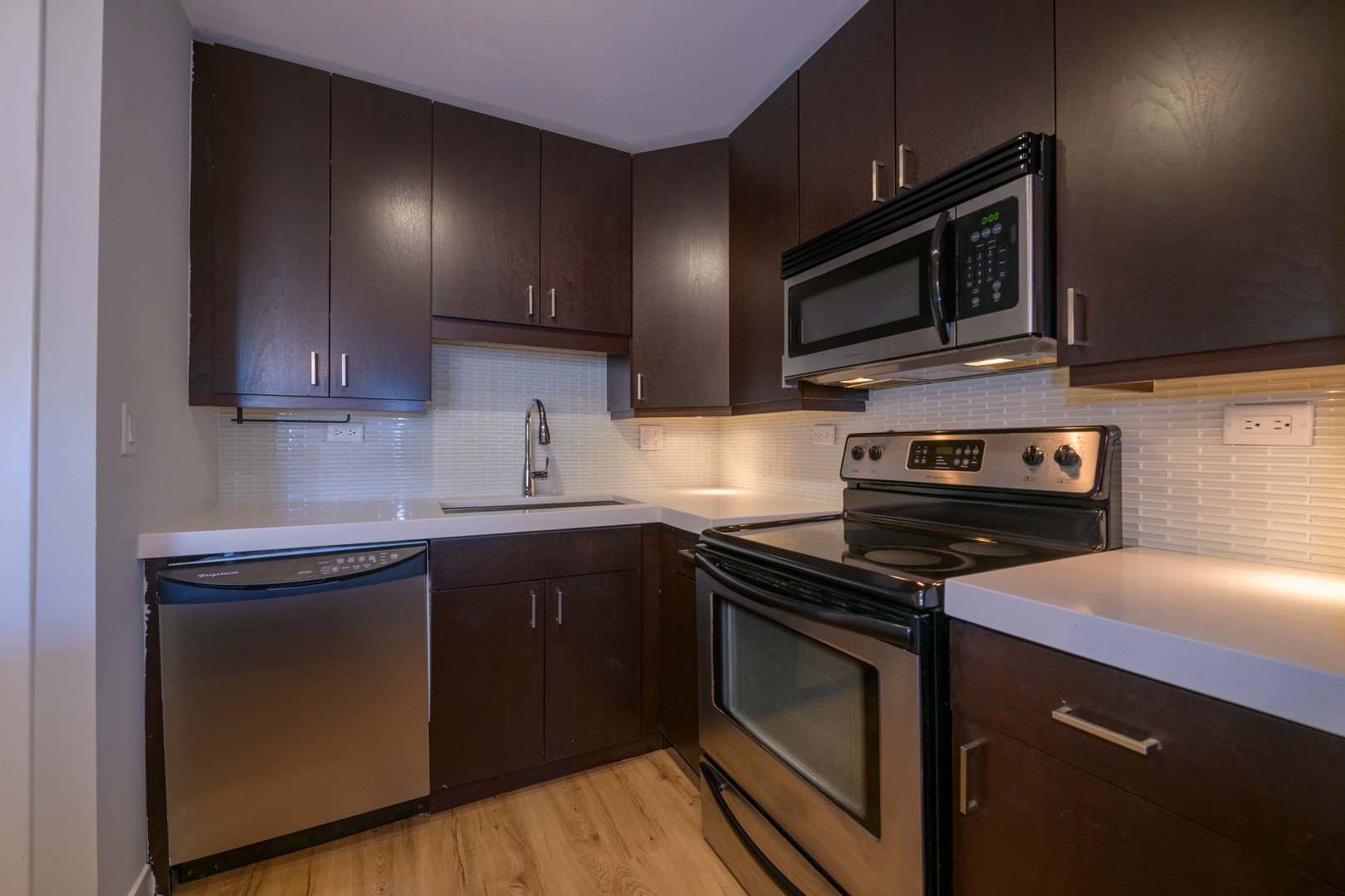 3033 North Sheridan Road, Unit 711 Chicago, IL 60657 - Photo 3 of 11 a kitchen with stainless steel appliances a stove microwave and sink