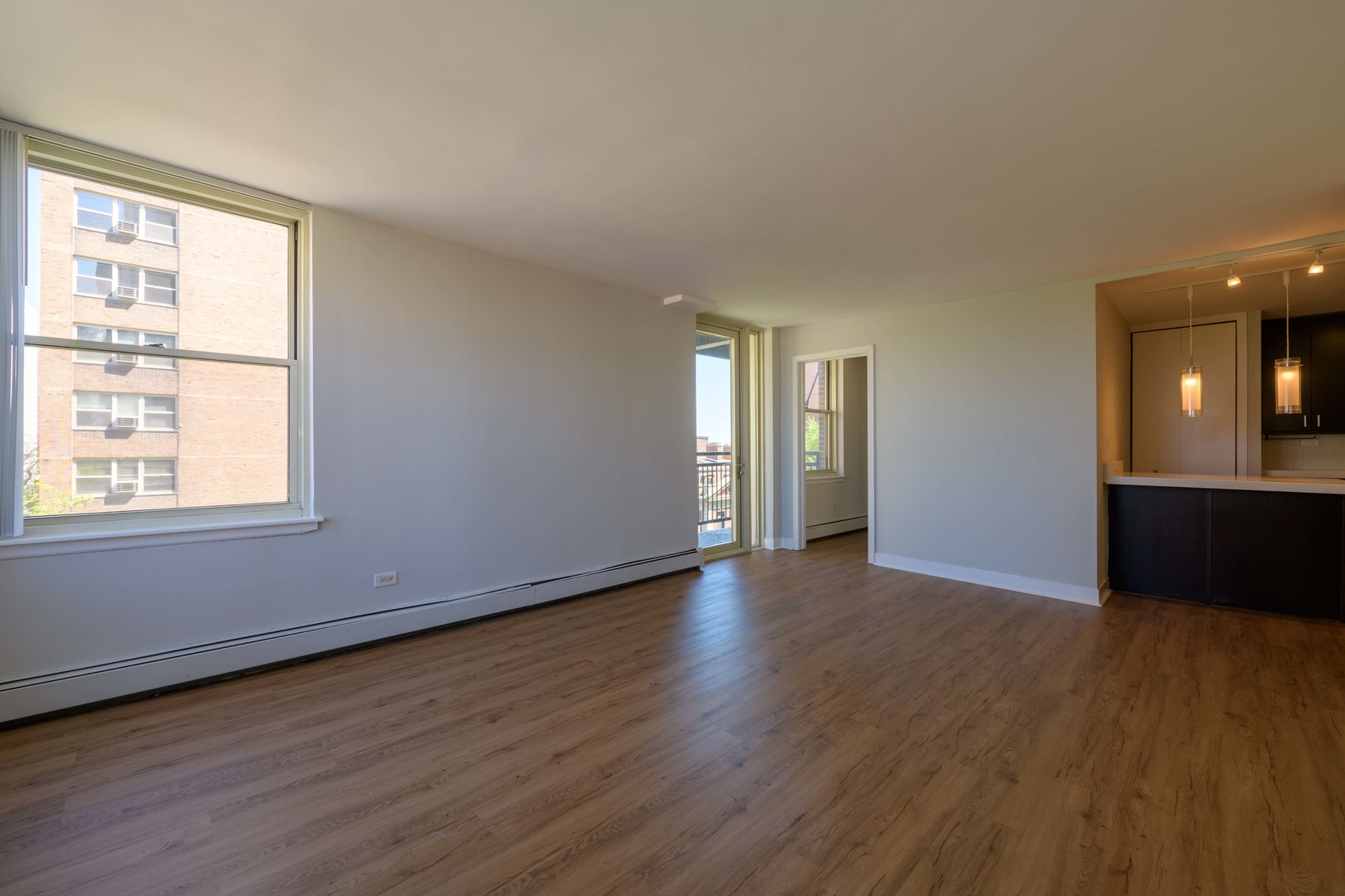 3033 North Sheridan Road, Unit 711 Chicago, IL 60657 - Photo 6 of 11 an empty room with wooden floor and windows