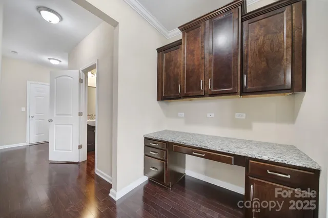 a kitchen with granite countertop wooden cabinets and a wooden floor