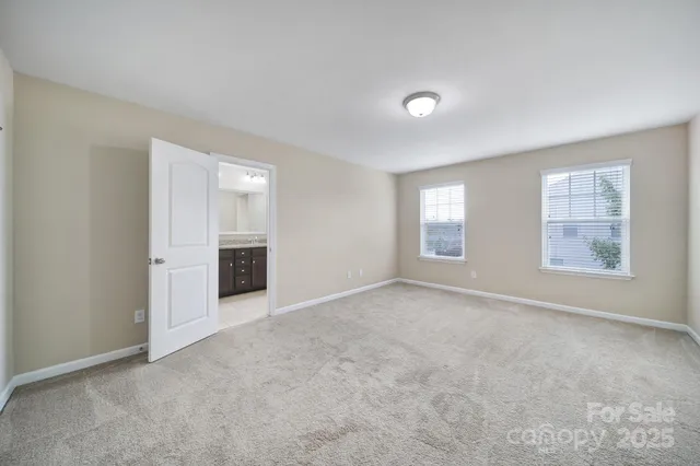 an empty room with windows and cabinet