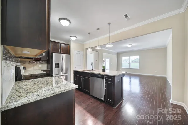 a large kitchen with kitchen island a sink stainless steel appliances and a counter top space