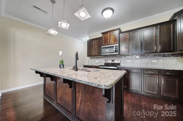 a kitchen with a center island cabinets and wooden floor