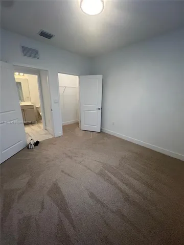 an empty room with cabinet and a mirror