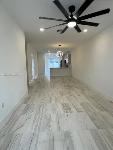 a large kitchen with a stove a sink a microwave a refrigerator and cabinets