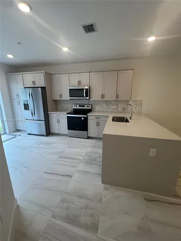 a kitchen with a stove and a refrigerator