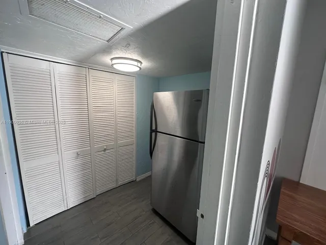 a bedroom with a bed and a flat tv screen on dresser