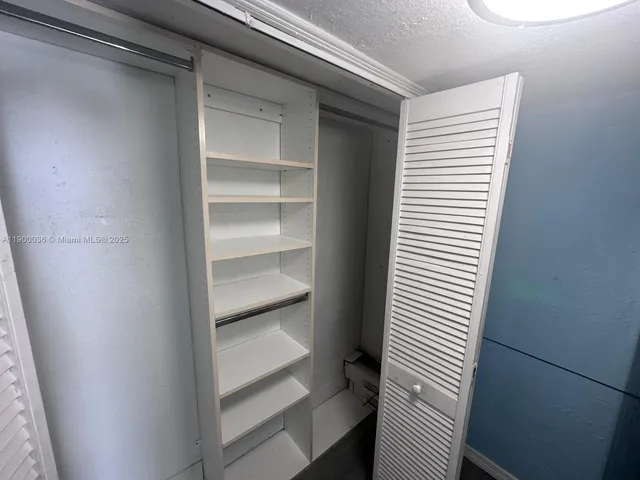 a bedroom with a bed and a flat tv screen on dresser