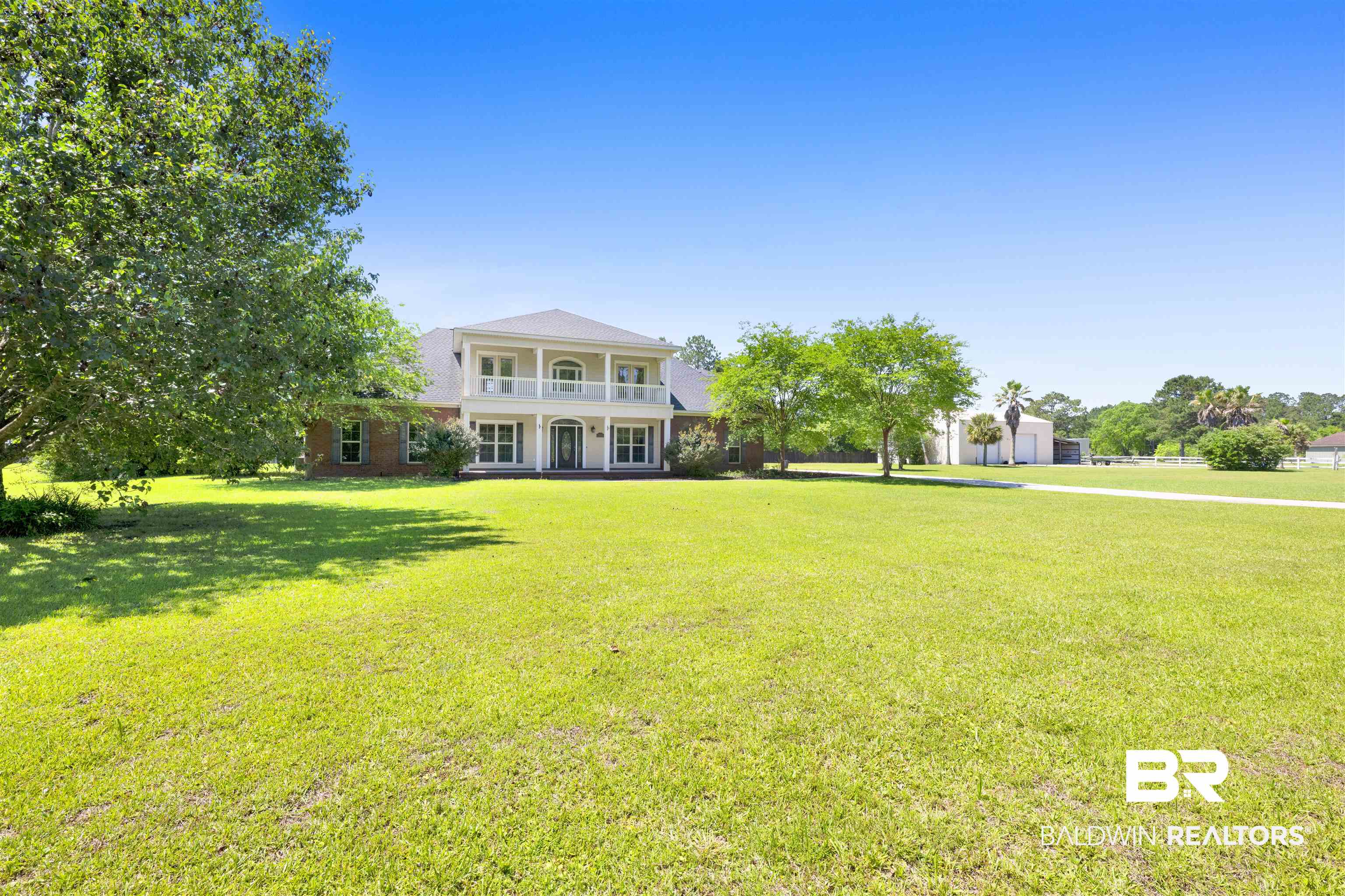 12944 Anna's Way Stapleton, AL 36578 - Photo 15 of 64 Southern Colonial-style residence featuring a brick facade, white columns, and dual-level balconies