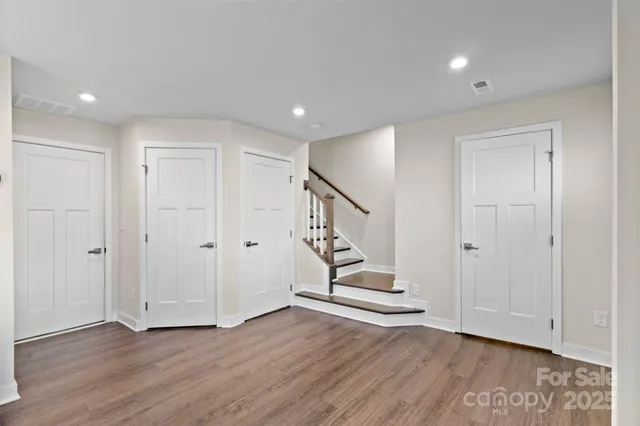 a view of an empty room with wooden floor and entryway