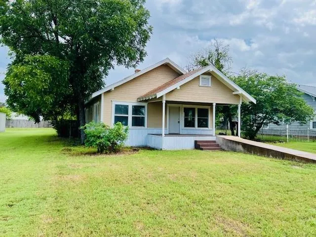 a front view of a house with a garden and yard