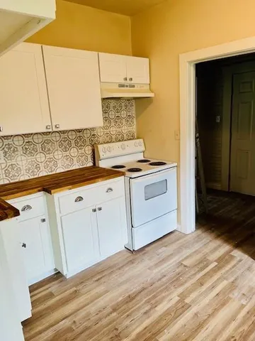 a kitchen with granite countertop white cabinets and white appliances