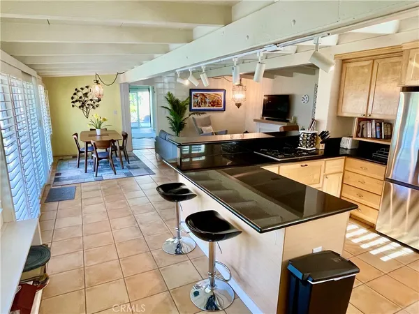 a kitchen with stainless steel appliances kitchen island granite countertop a table and chairs in it