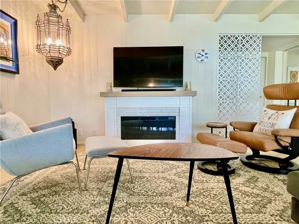 a living room with furniture a flat screen tv and a fireplace