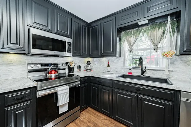 a kitchen with stainless steel appliances granite countertop a sink stove and microwave