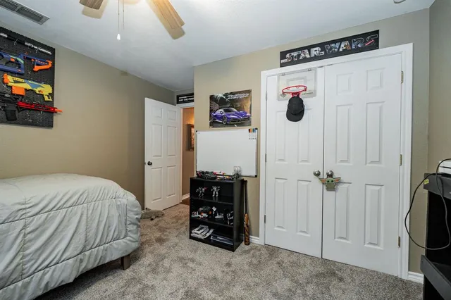 a bedroom with a bed a couch and a flat tv screen