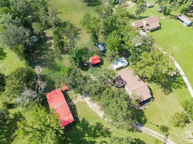 an aerial view of a house with a yard and lake view