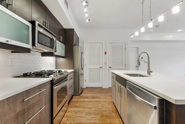 a kitchen with stainless steel appliances granite countertop a sink and stove top oven