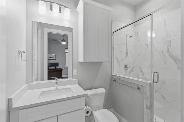 a large white kitchen with a refrigerator a stove a sink dishwasher a dining table and chairs with wooden floor