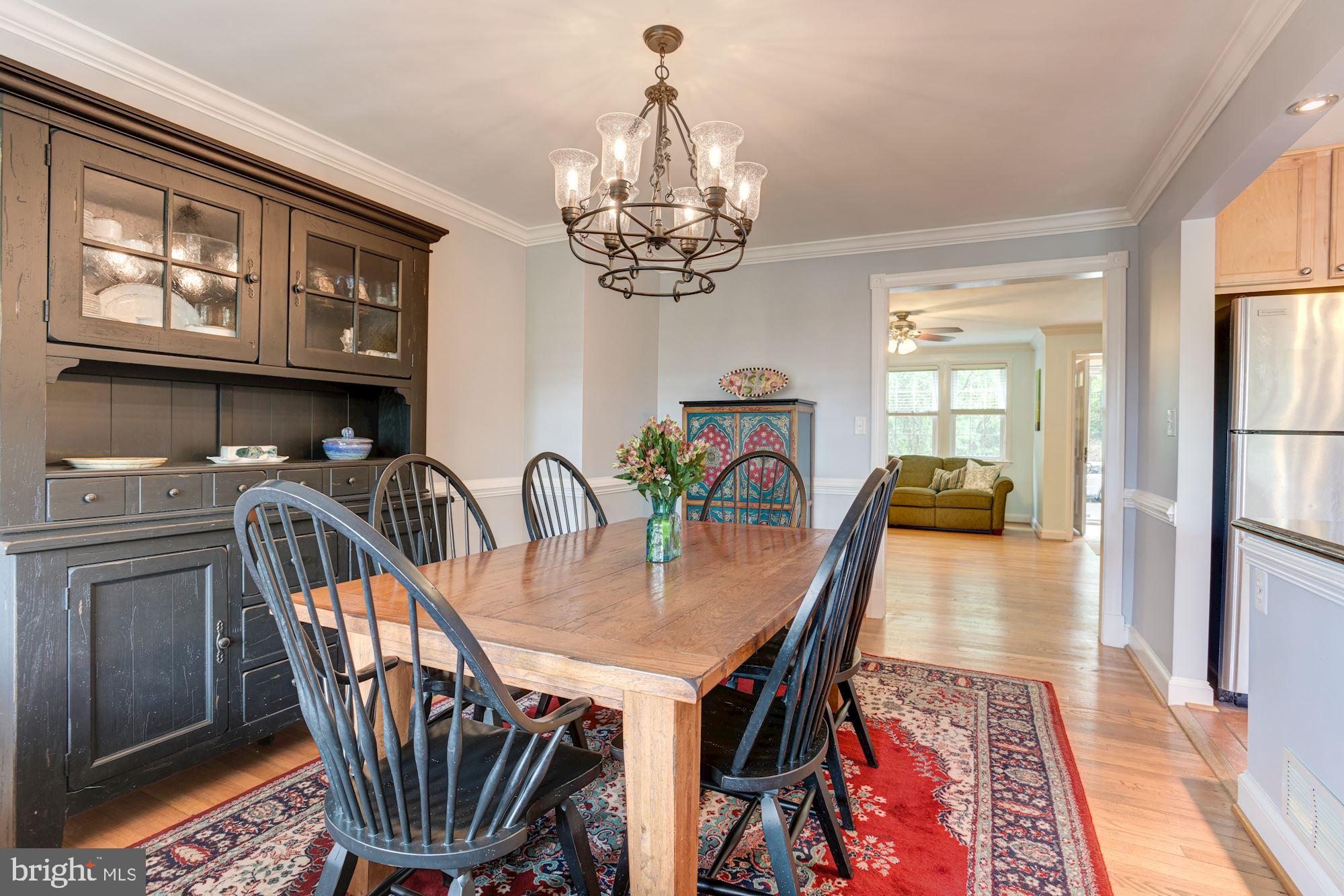 417 Whitfield Road Baltimore, MD 21228 - Photo 3 of 31 a dining room with furniture a chandelier and wooden floor