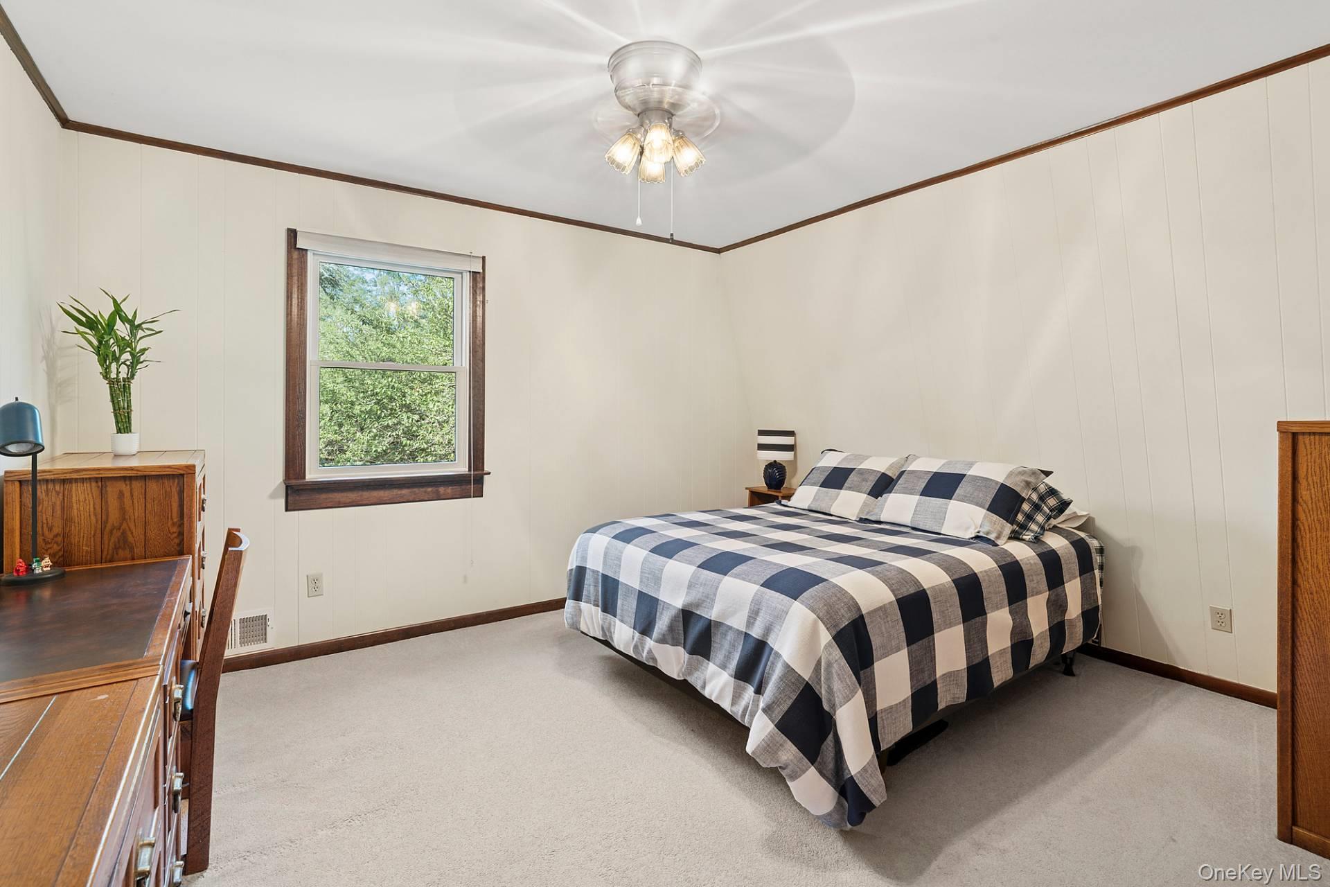 28 Plain View Drive Wading River, NY 11792 - Photo 16 of 20 a bedroom with a bed and a chandelier