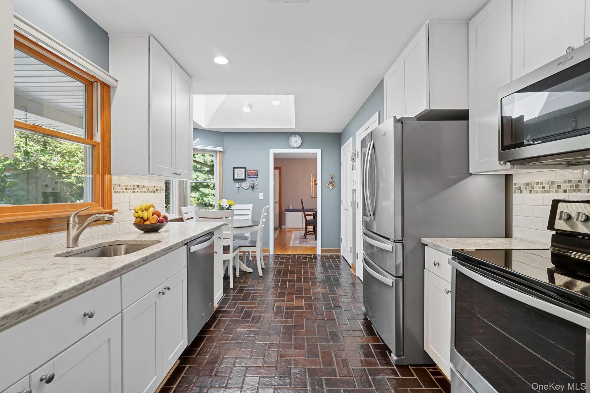 28 Plain View Drive Wading River, NY 11792 - Photo 2 of 20 a kitchen with stainless steel appliances a sink stove refrigerator and a window