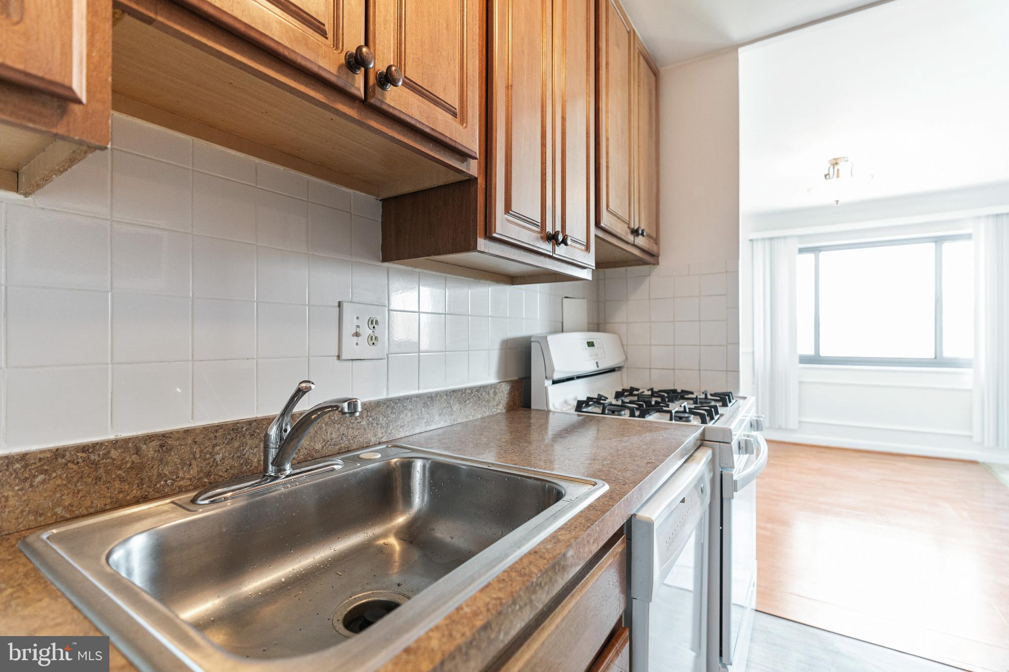 1300 South Arlington Ridge Road, Unit 402 Arlington, VA 22202 - Photo 4 of 23 a kitchen with stainless steel appliances granite countertop a sink and a stove next to a window