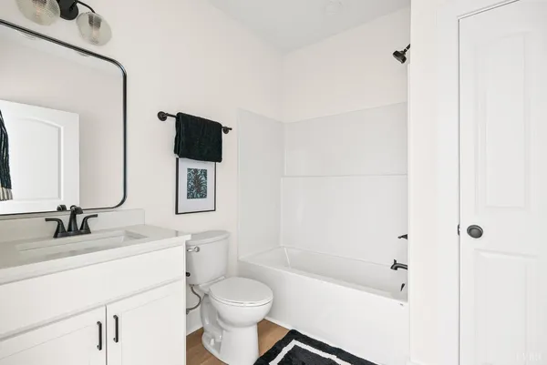 a bathroom with a bathtub shower sink vanity and toilet
