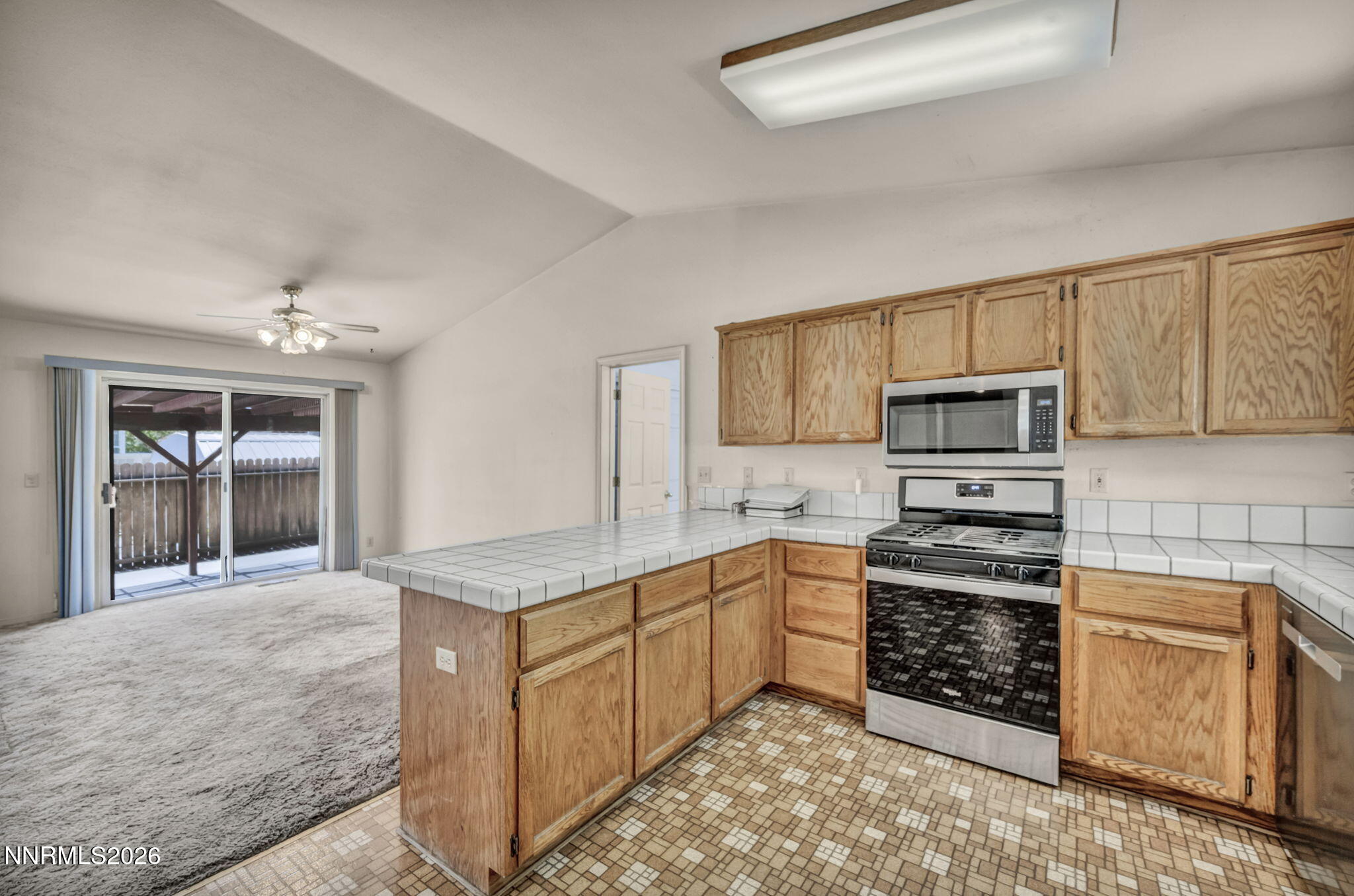 692 Lassen Way Gardnerville, NV 89460 - Photo 12 of 34 a kitchen with stainless steel appliances granite countertop a stove top oven a sink dishwasher and a refrigerator with wooden cabinets