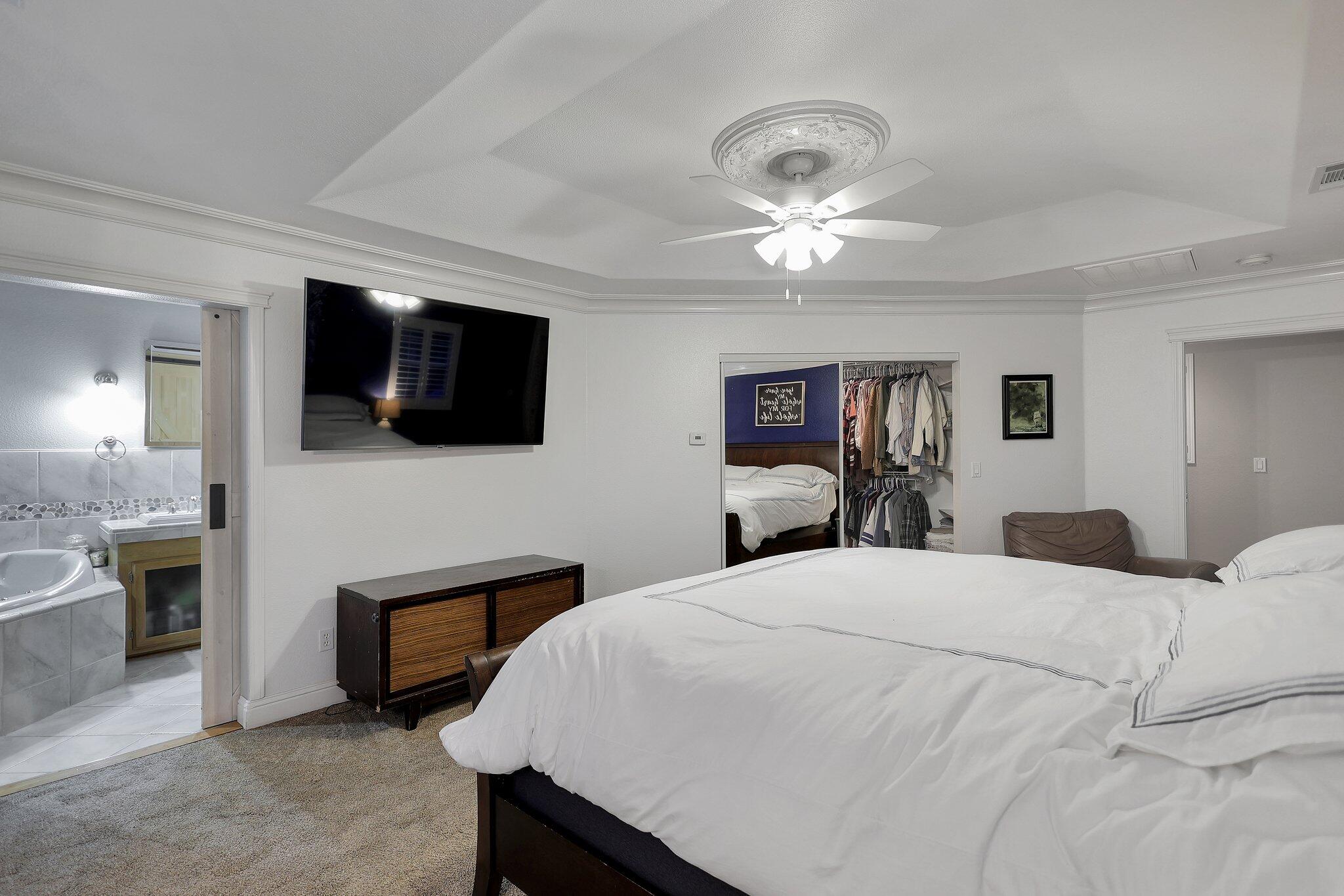 720 Lakeview Drive Redding, CA 96001 - Photo 17 of 38 a spacious bedroom with a bed and a flat screen tv