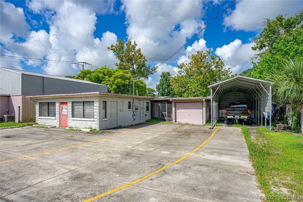 a front view of a house with a yard and potted plants