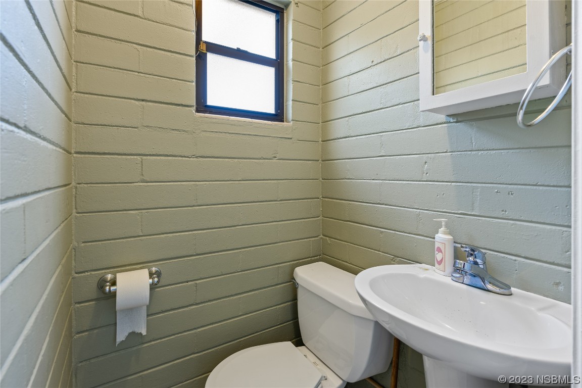 108 South Ridgewood Avenue Edgewater, FL 32132 - Photo 15 of 23 a bathroom with a toilet a sink and mirror