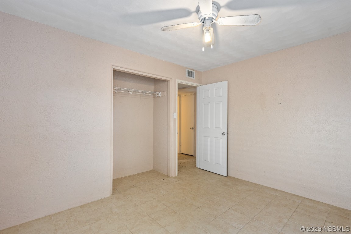 108 South Ridgewood Avenue Edgewater, FL 32132 - Photo 8 of 23 an empty room with a chandelier fan and closet area