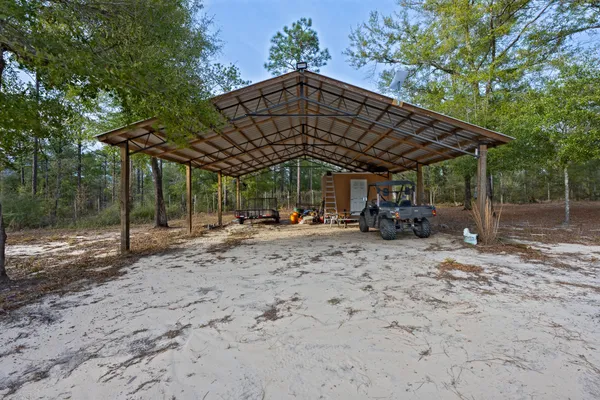 a view of a large yard with a table and chairs under an umbrella
