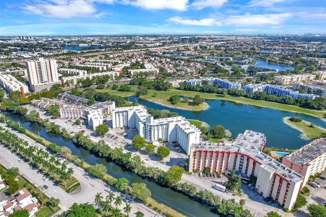 an aerial view of a city with swimming pool and lake view in back
