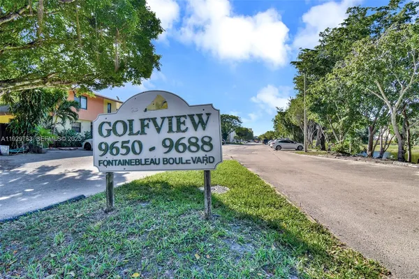 a view of a street sign under a large tree