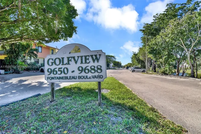 a view of a street sign under a large tree