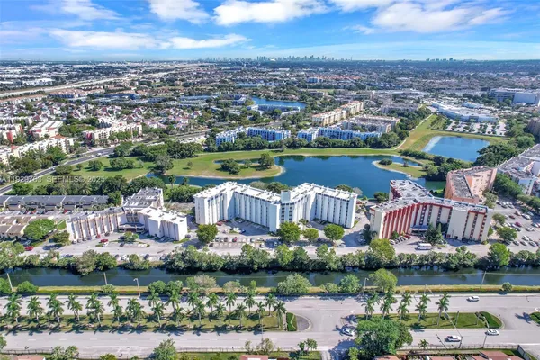 an aerial view of a city with lots of residential buildings and lake view in back