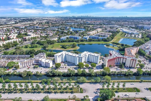 an aerial view of a city with lots of residential buildings and lake view in back